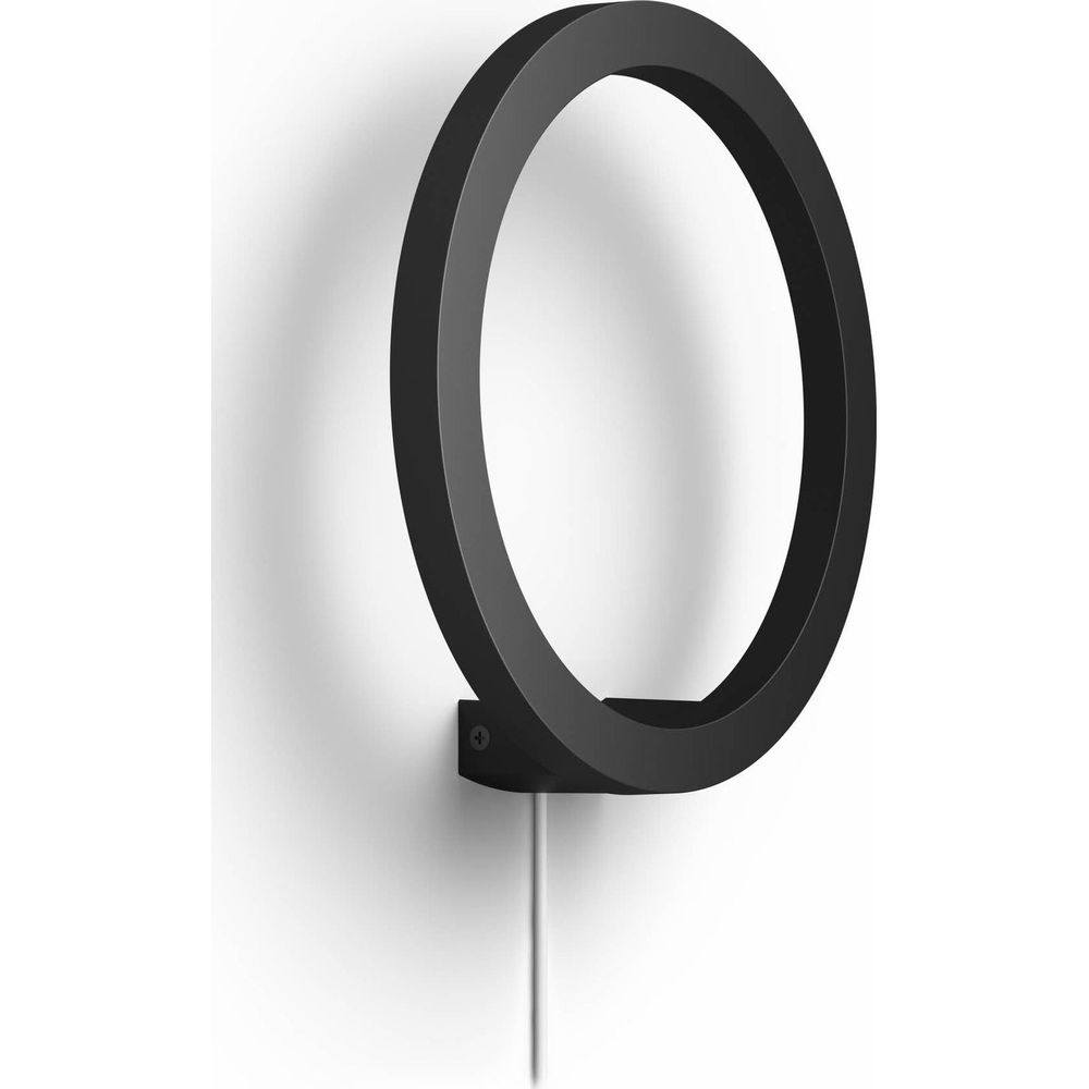 Czarny, okrągły pierścień ścienny z białym kablem wisi na białej ścianie.