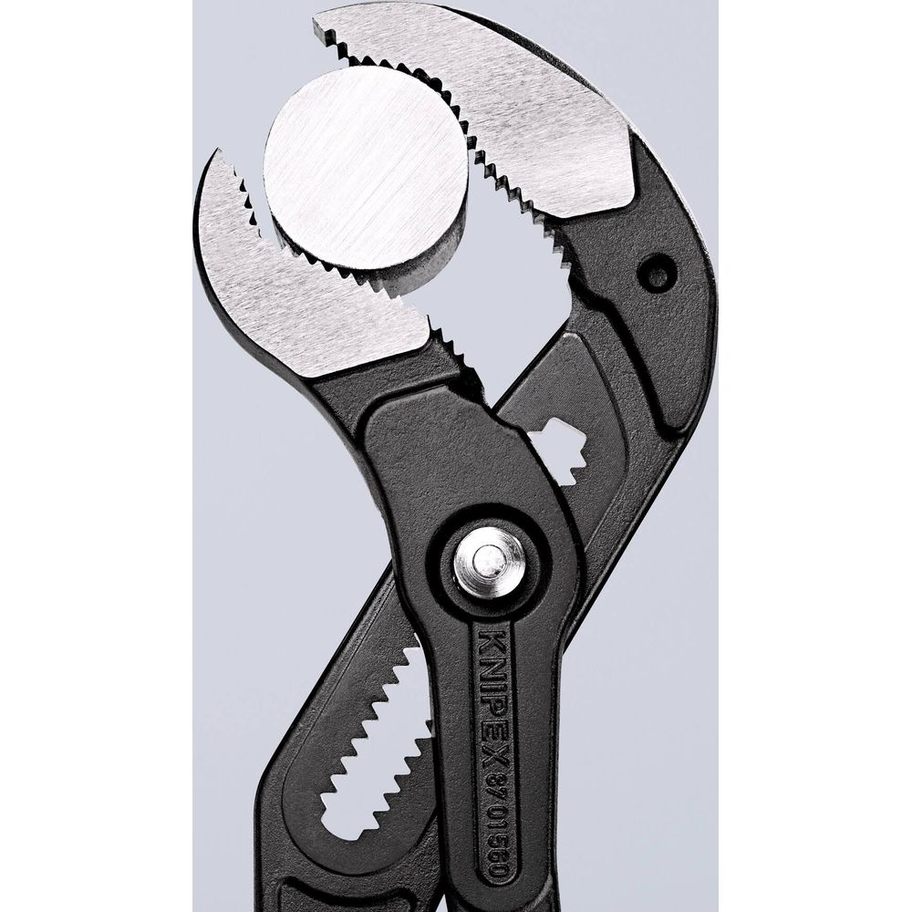 Szczypce nastawne trzymają okrągły metalowy dysk z ząbkowanymi szczękami.