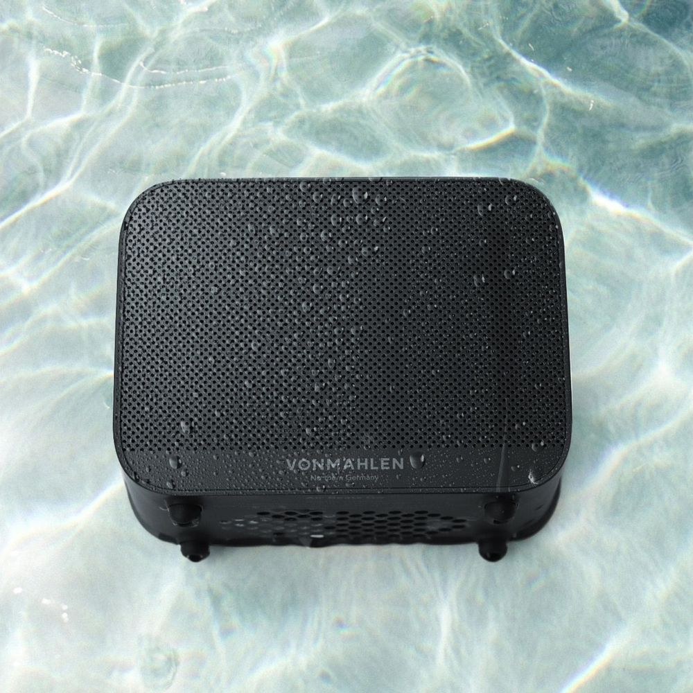 Schwarzer Lautsprecher mit Wassertropfen im Pool.