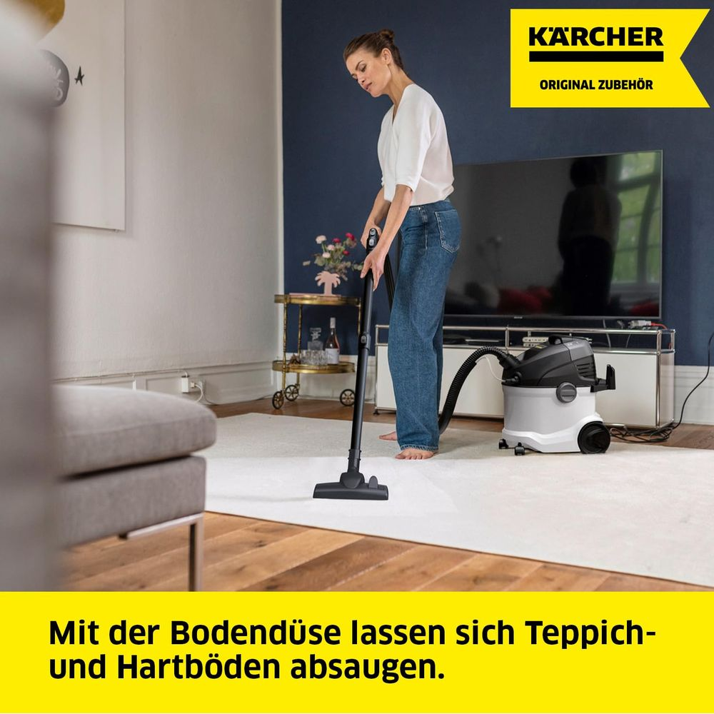 Kobieta odkurza dywan odkurzaczem Karcher.