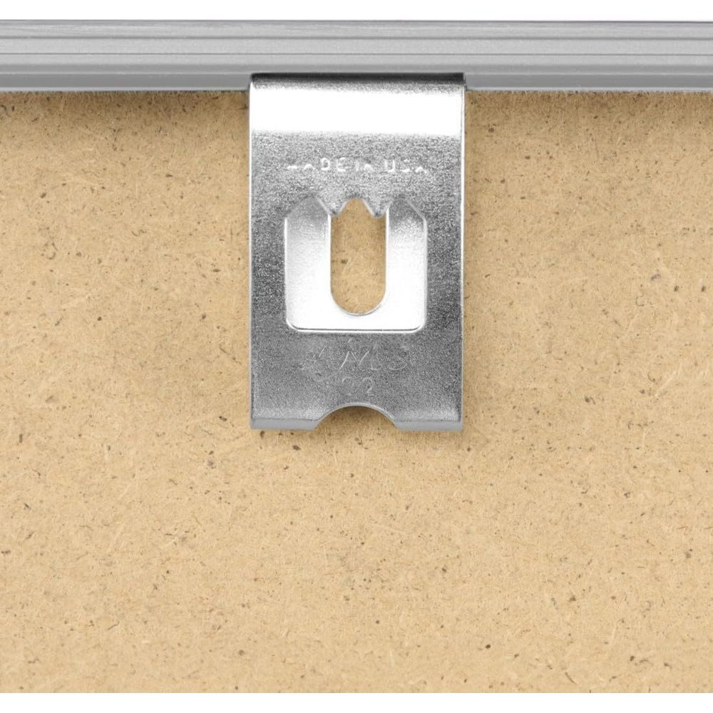 Srebrny haczyk z napisem 'Made in USA' wisi na drewnianej ścianie.