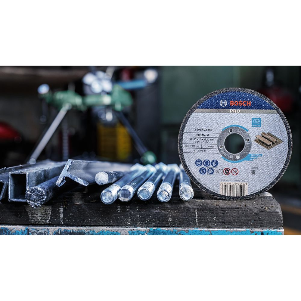 Tarcza tnąca Bosch do metalu na drewnianym stole z prętami metalowymi.