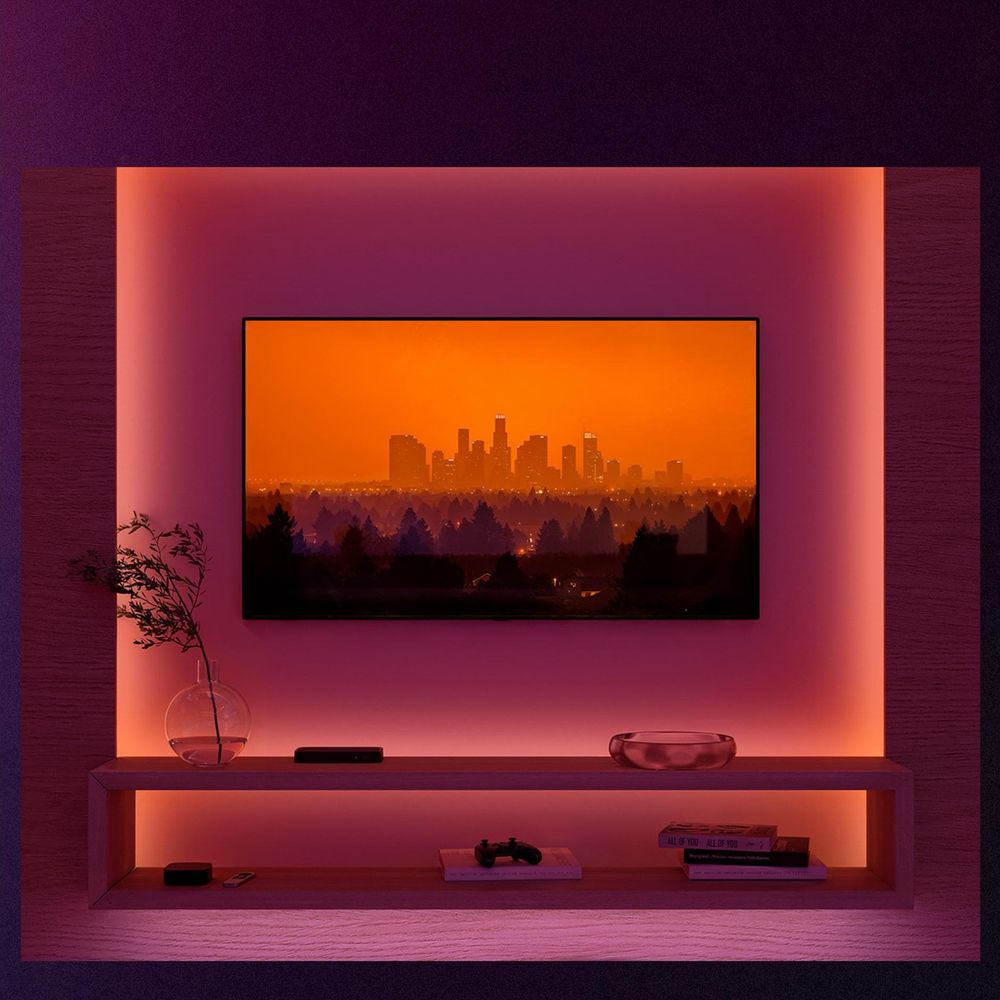 Televisor mostrando un horizonte al atardecer, rodeado de luz ambiental rosa.
