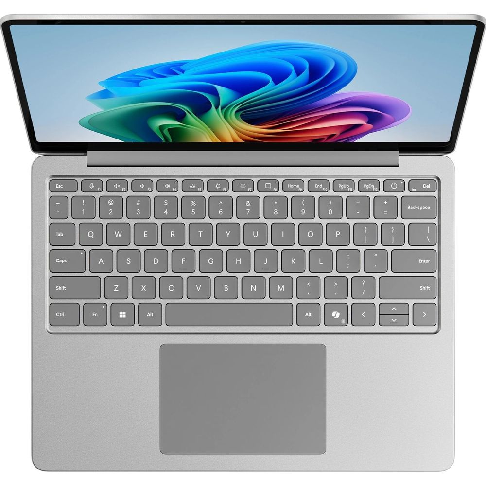 Ein silberner Laptop ist geöffnet und zeigt einen bunten Hintergrund auf dem Bildschirm.
