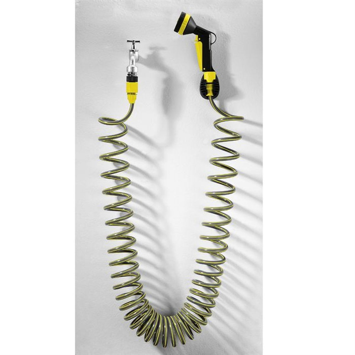 Sarı vurgulu spiral hortum, musluğun ve püskürtme tabancasının yanında duvara asılıdır.