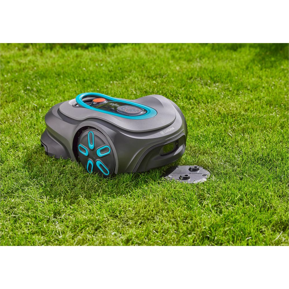 Ein Mähroboter auf einem Rasen mit einer Ladestation.