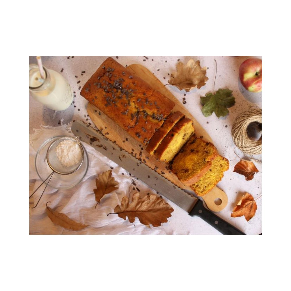 Ein geschnittener Kuchen mit Schokoladenstückchen, Milch, Apfel und Herbstblättern.