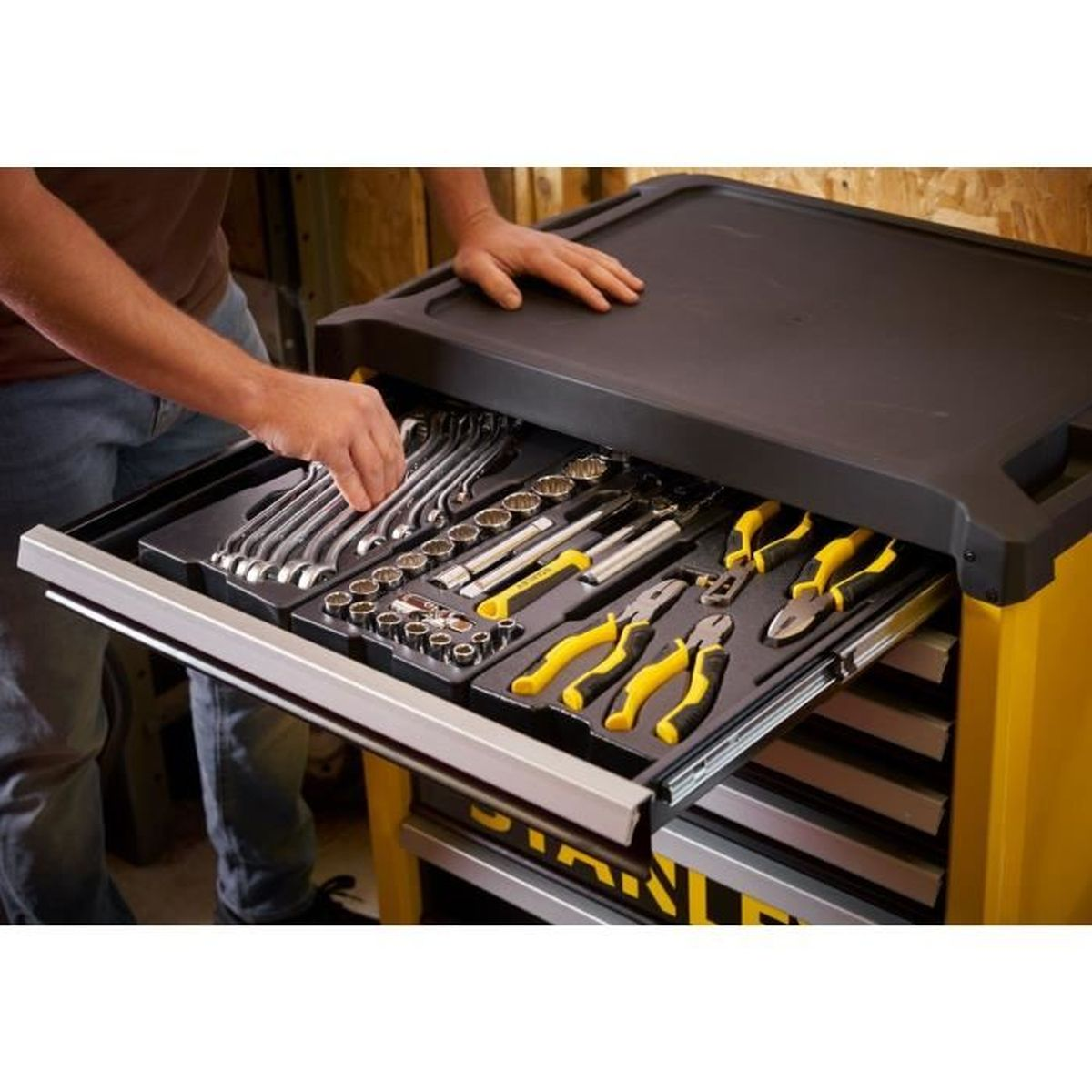 Caja de herramientas con cajones abiertos llenos de herramientas como llaves y alicates.