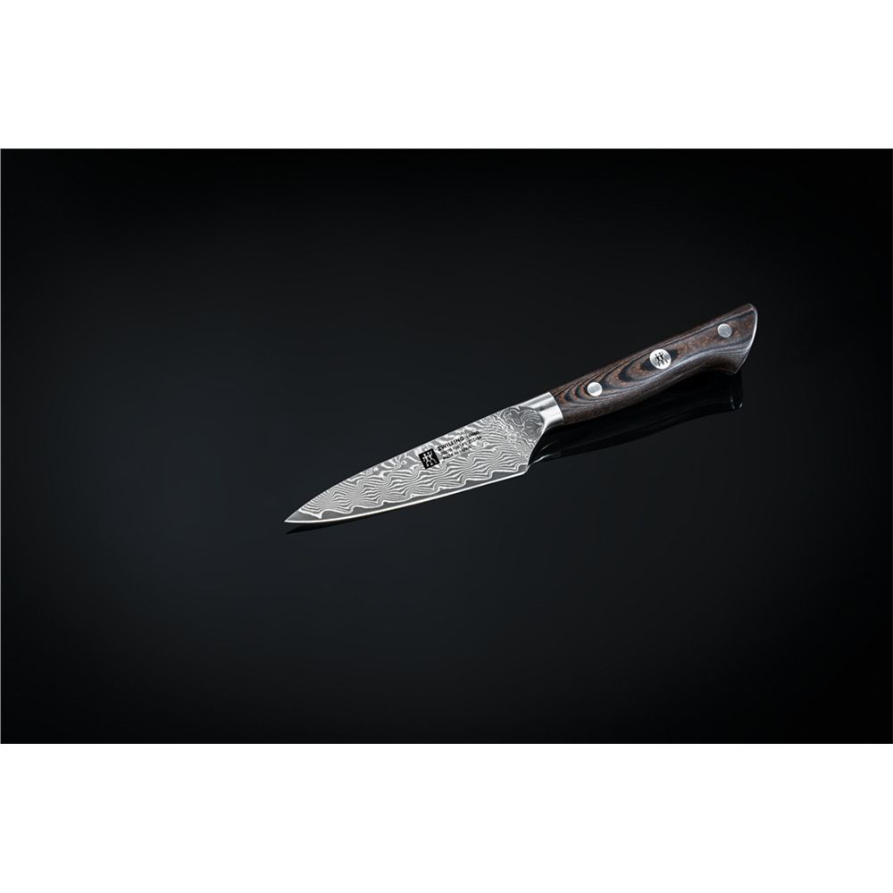 Nóż kuchenny Damasceński z ciemną drewnianą rączką leży na czarnej, odbijającej powierzchni.