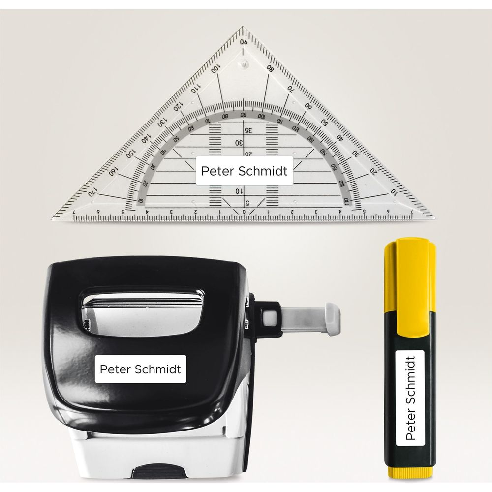 Ein Dreieckslineal, ein Stempel und ein Textmarker mit Namen Peter Schmidt.