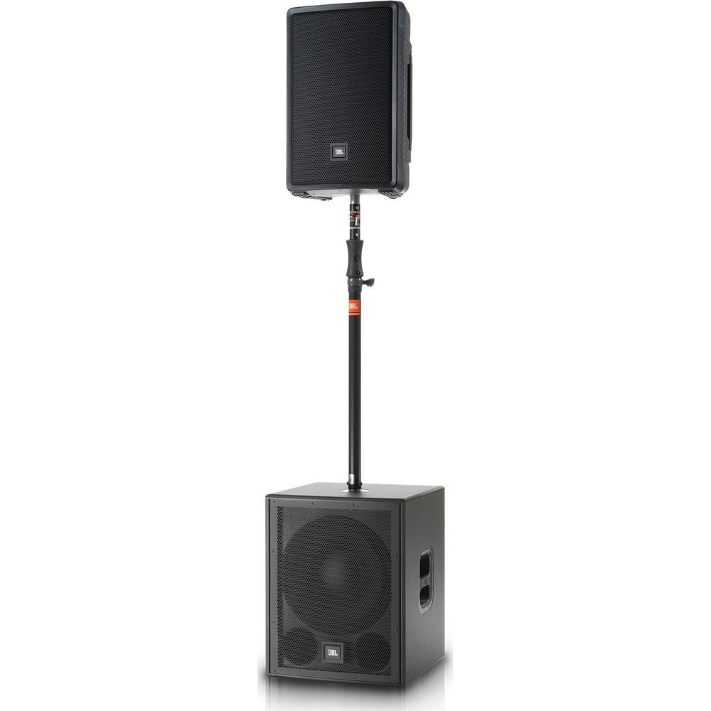 Un subwoofer JBL negro está en el suelo con un altavoz negro sobre un soporte encima.