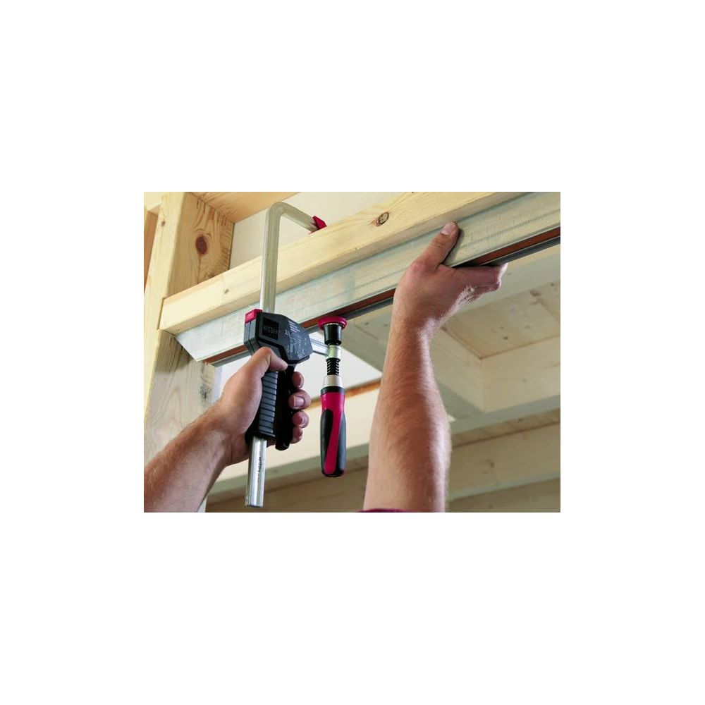 Osoba używa ścisku do mocowania drewna.