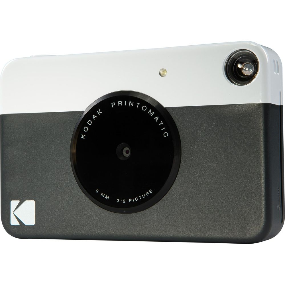 Una fotocamera Kodak Printomatic bianca e grigia con obiettivo e flash.