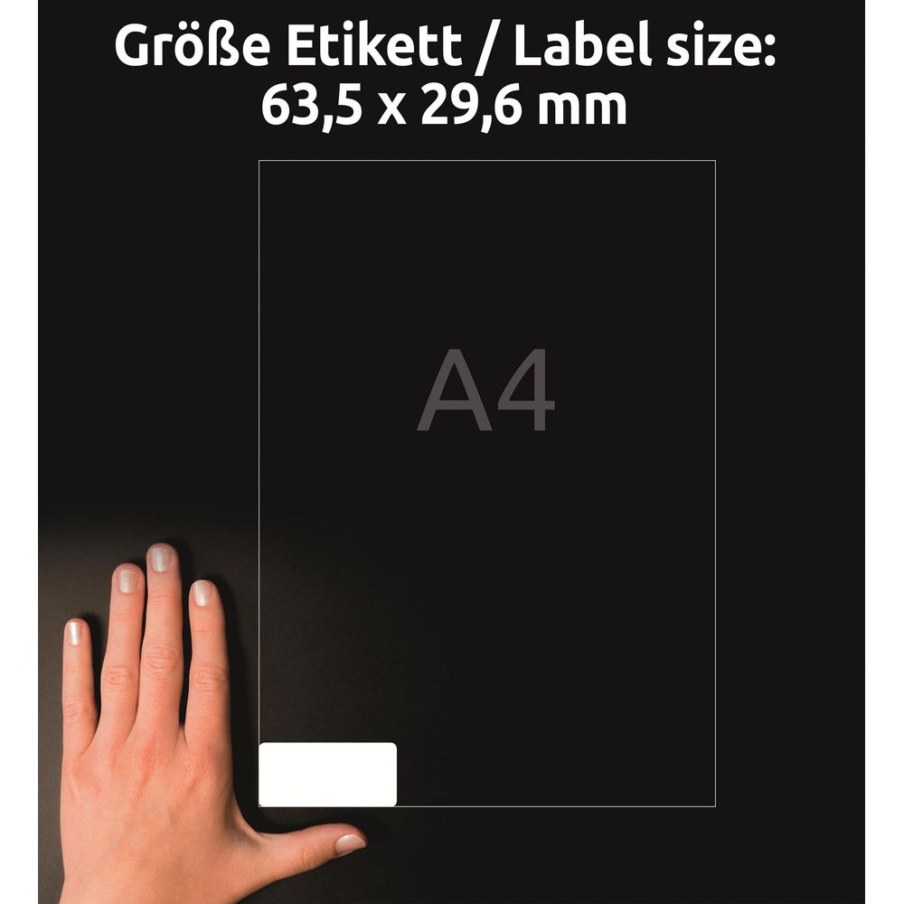 Eine Hand liegt neben einem Blatt Papier mit der Aufschrift A4. Oben steht: Größe Etikett 63,5 x 29,6 mm.