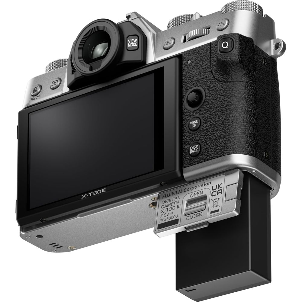 Zilveren Fujifilm X-T30 III camera met zwarte grip en open batterijcompartiment.