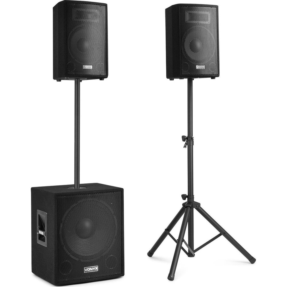 Dos altavoces negros en soportes, uno sobre un subwoofer.