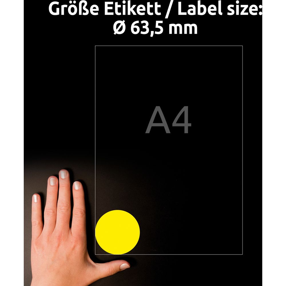 Eine Hand hält ein gelbes Etikett vor einem schwarzen Hintergrund mit A4-Markierung.