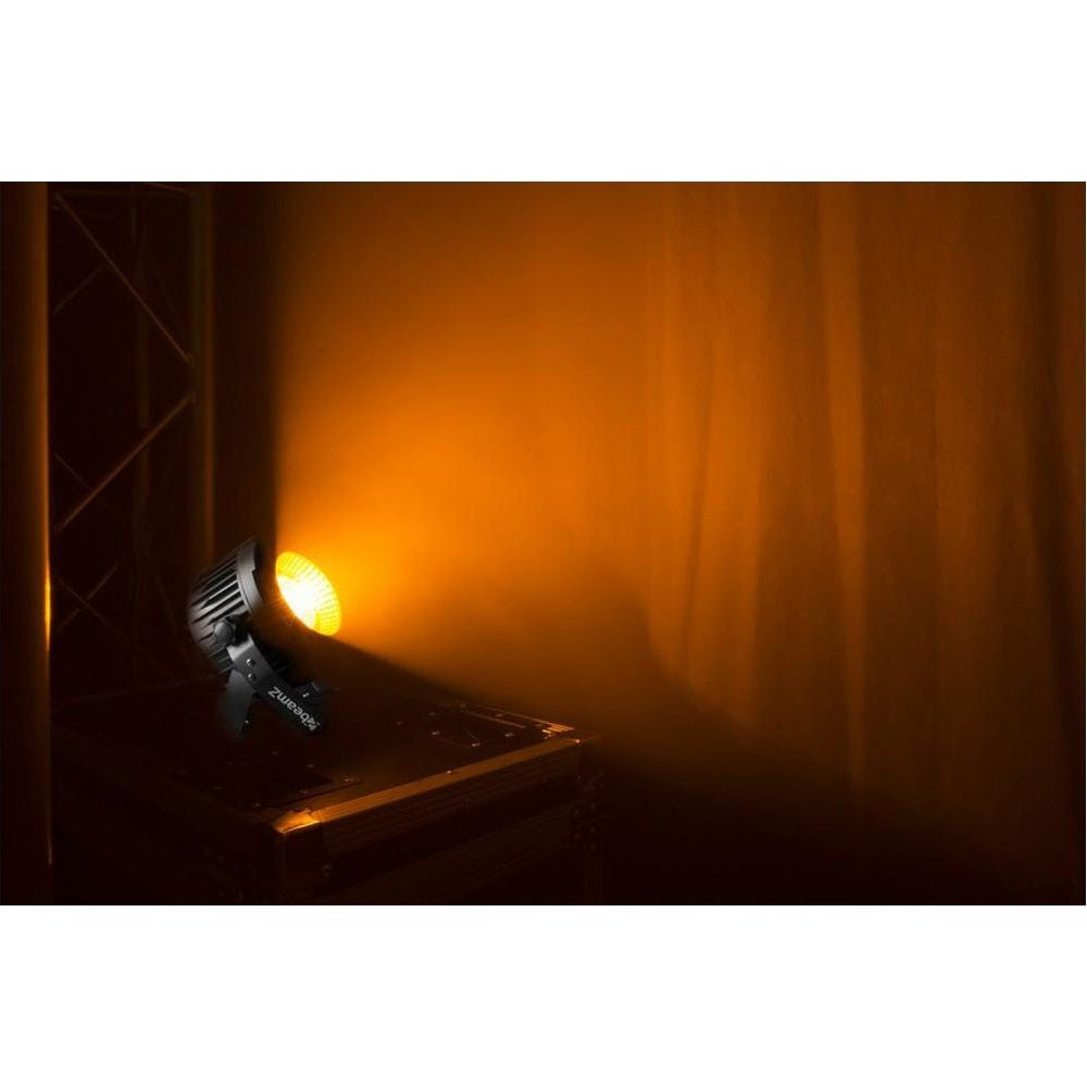 Un foco proyecta luz naranja sobre una pared.