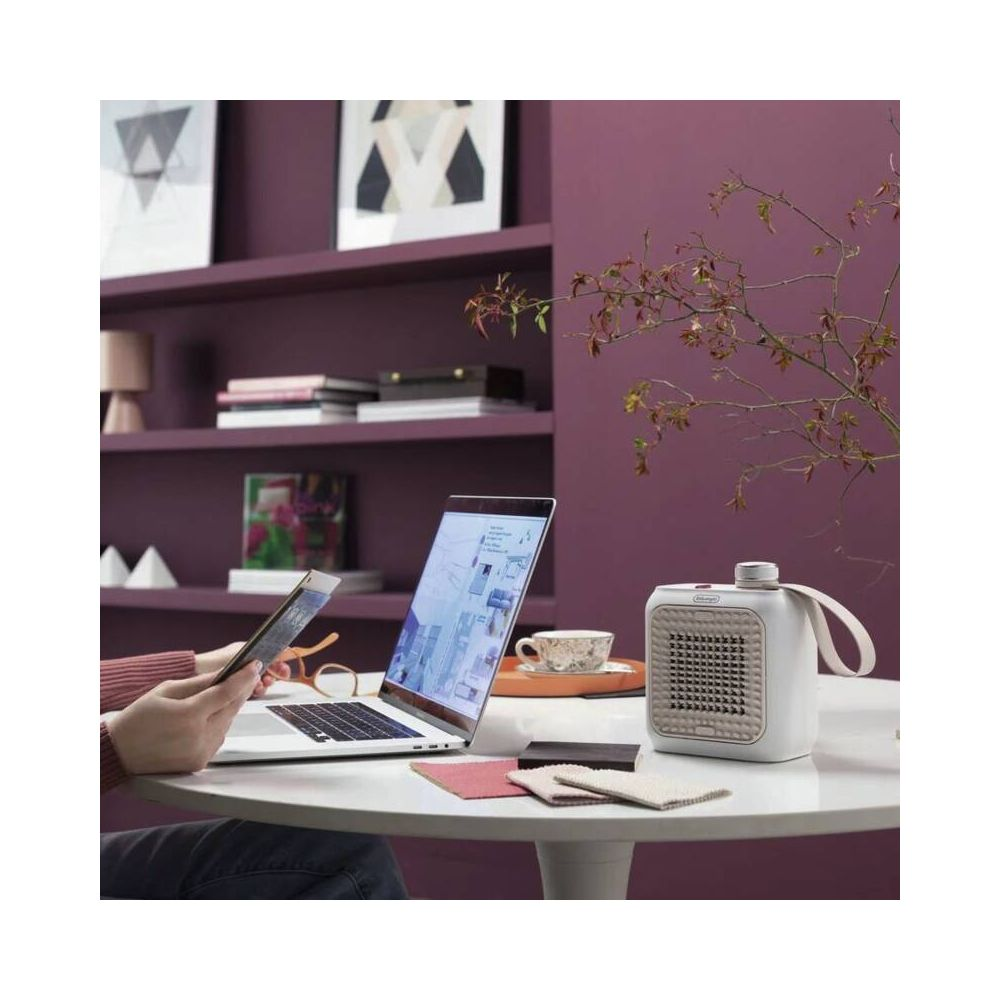 Osoba używa tabletu przed laptopem, obok mała grzałka.