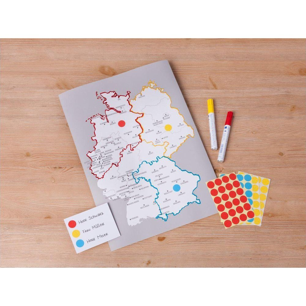 Eine Deutschlandkarte mit Bundesländern, Markern und Stiften auf Holzhintergrund.