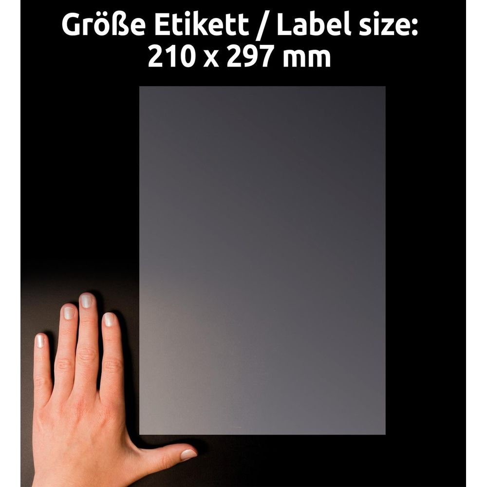 Eine Hand vergleicht die Größe eines A4-Etiketts auf schwarzem Hintergrund.