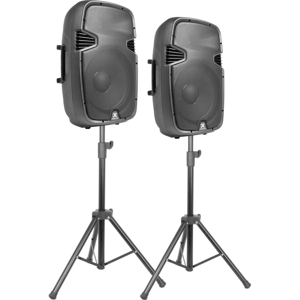 Dos altavoces negros sobre soportes, fondo blanco.