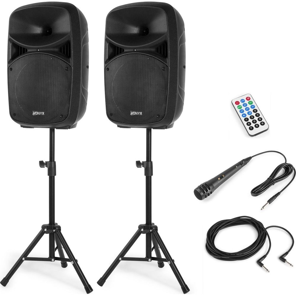 Dos altavoces negros sobre soportes con mando, micrófono y cable.