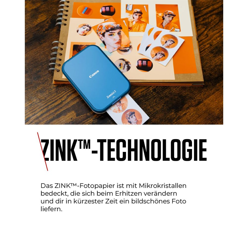 Una impresora Canon Zoemini 2 azul descansa sobre un álbum de fotos.