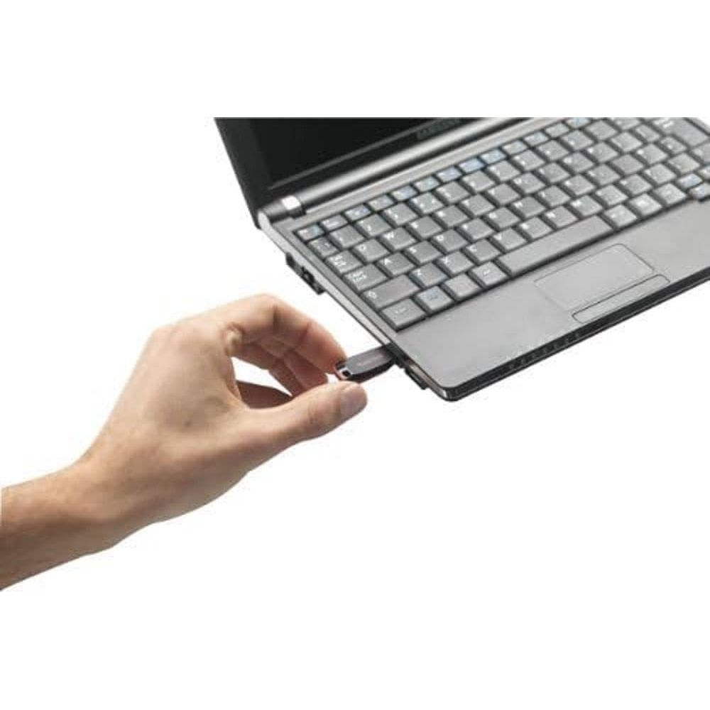 A hand inserts a USB stick into a laptop.