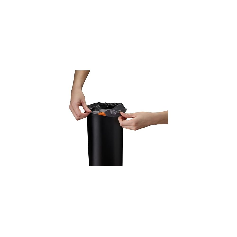 Manos colocando una bolsa de basura negra sobre un cubo negro.