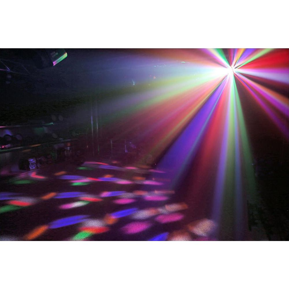 Rayos de luz coloridos iluminan una habitación oscura con patrones reflectantes en el suelo.