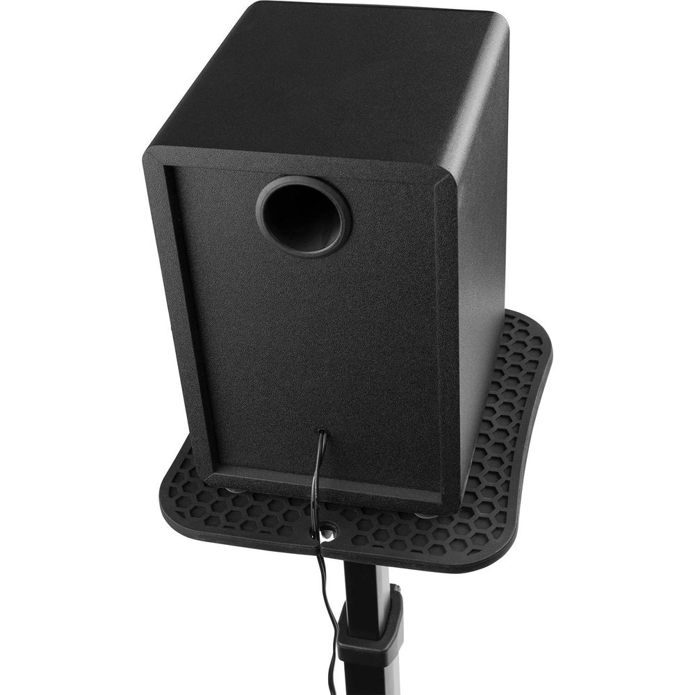 Subwoofer negro con puerto redondo sobre un soporte texturizado.