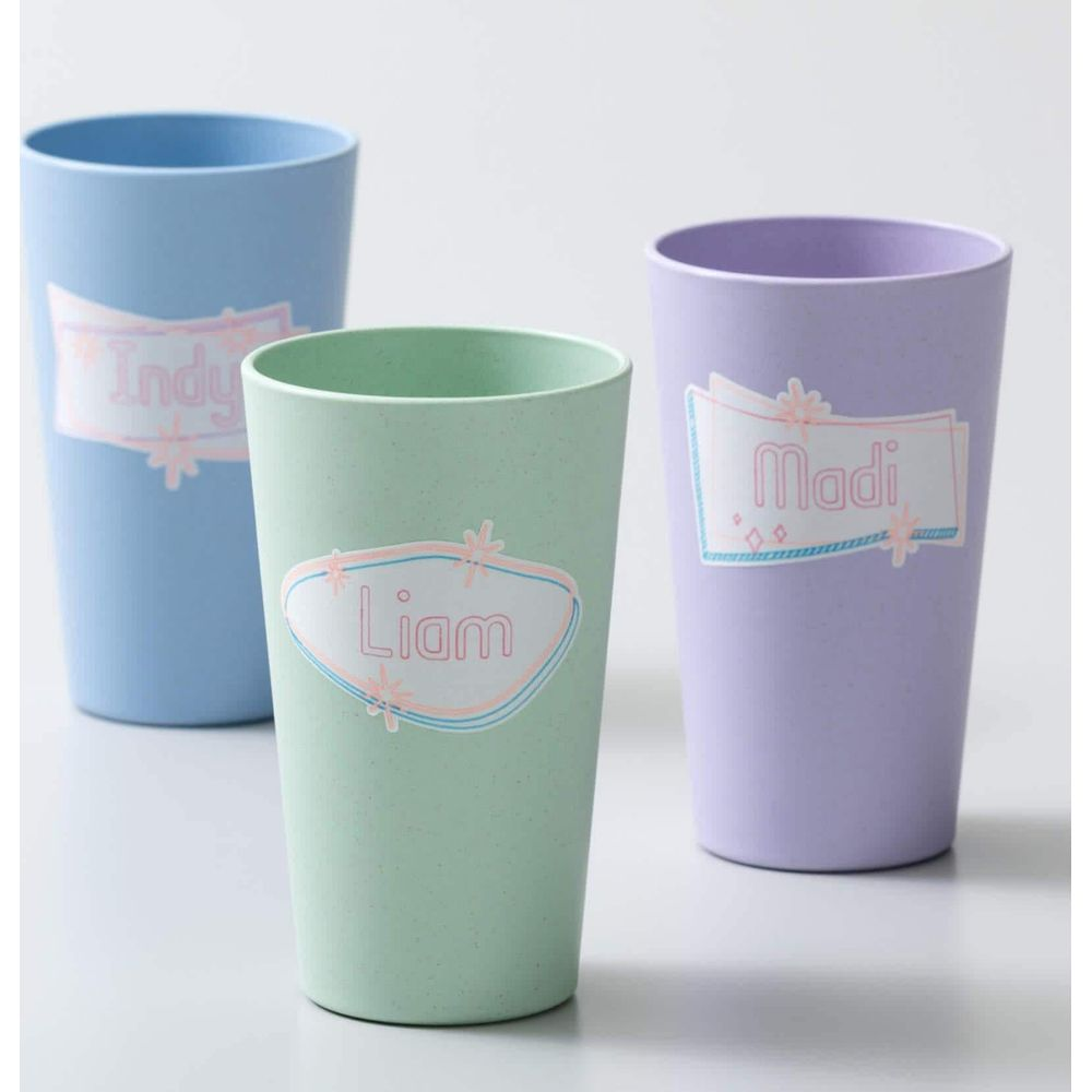 Drei Becher in Pastelltönen: Hellgrün, Hellblau und Lavendel, mit Namen.