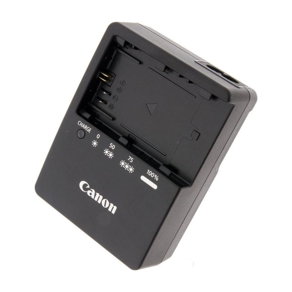Cargador de batería Canon negro con indicadores de carga y compartimento.