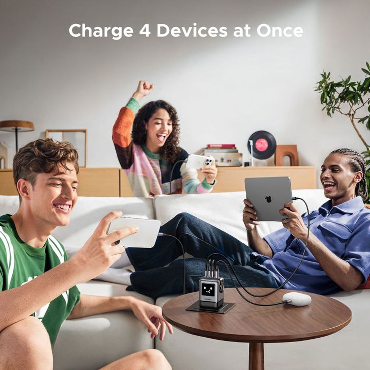 Trzech przyjaciół ładuje urządzenia na sofie, blok ładowania ma twarz.