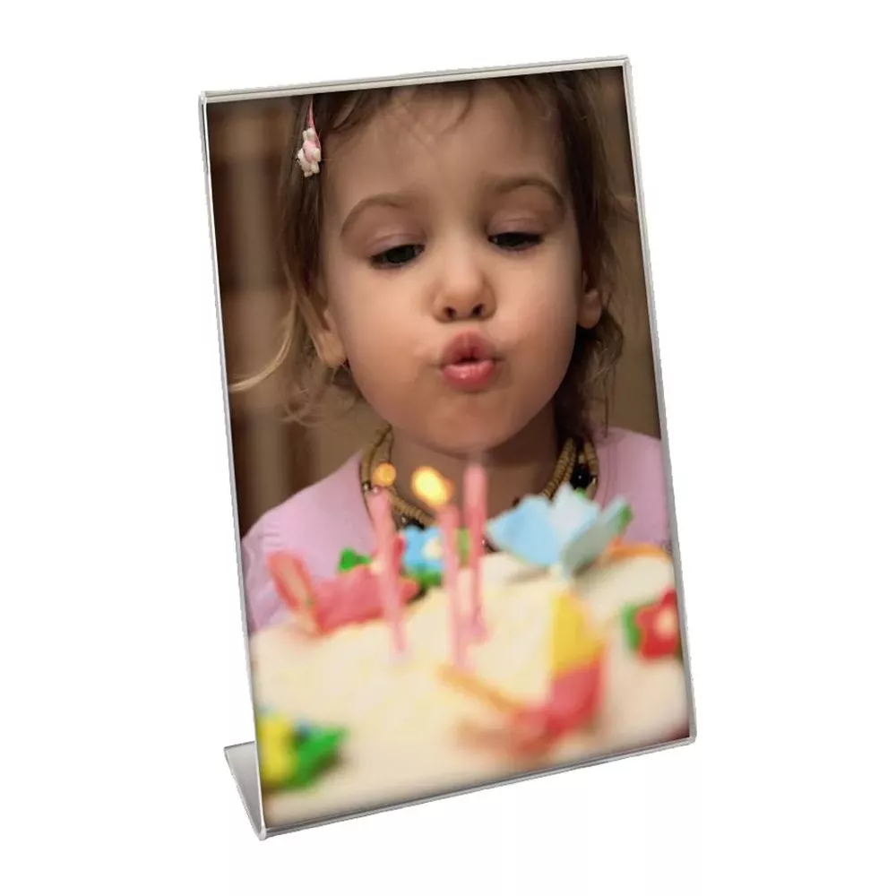 Ein kleines Mädchen bläst Kerzen auf einem Kuchen aus.