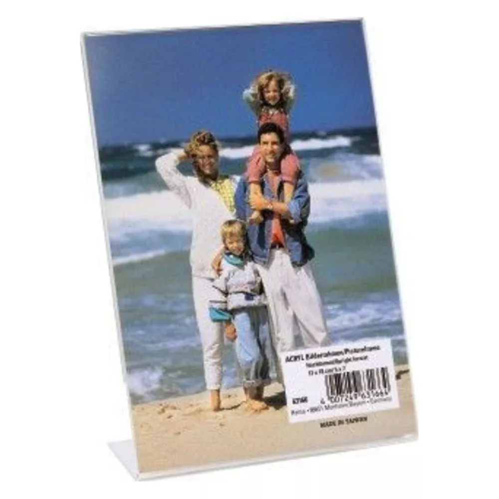Familie am Strand: Vater trägt Kind auf Schultern, Mutter und kleines Kind stehen daneben.