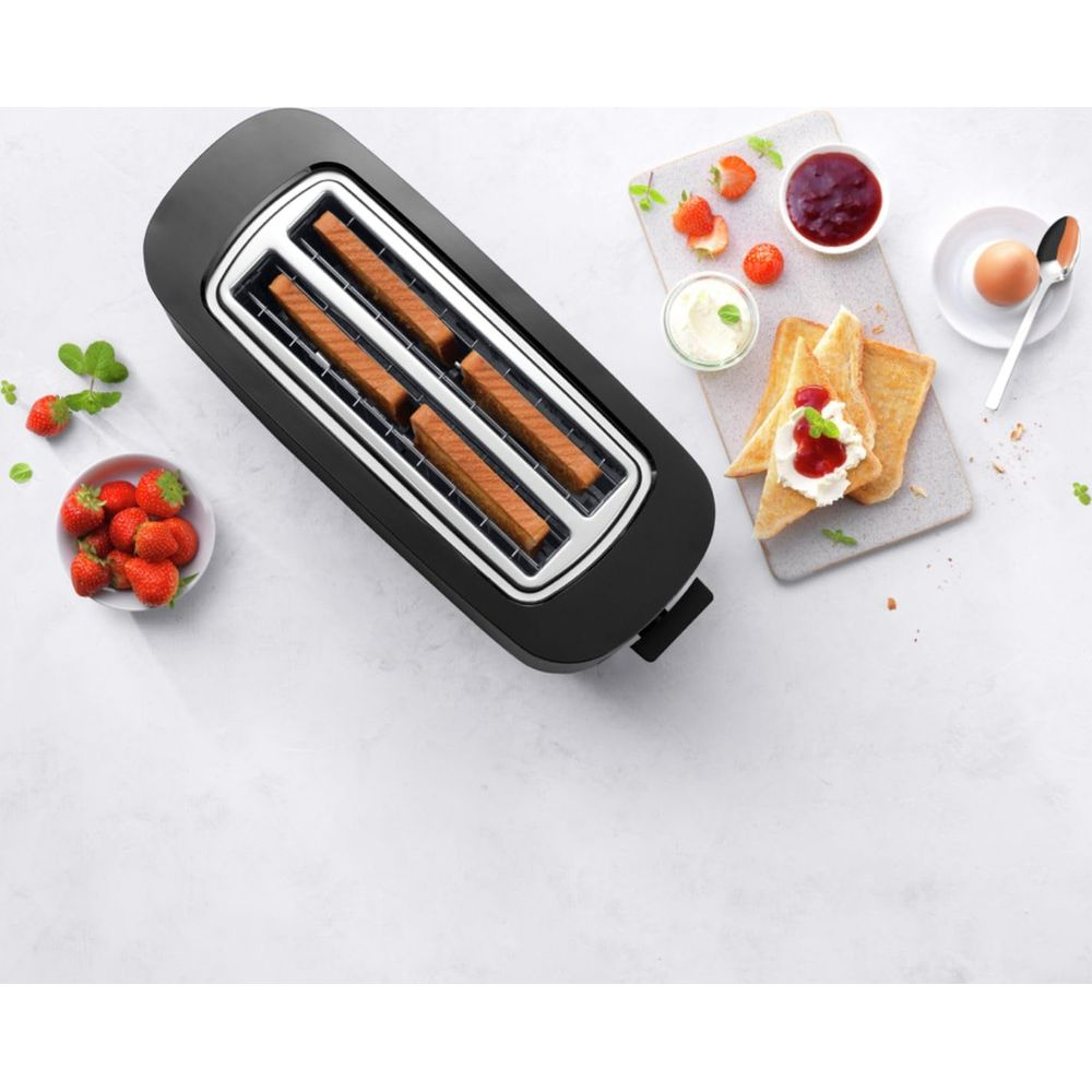 Czarny toster z czterema slotami zawiera chleb. W pobliżu znajdują się truskawki i tosty z dżemem.