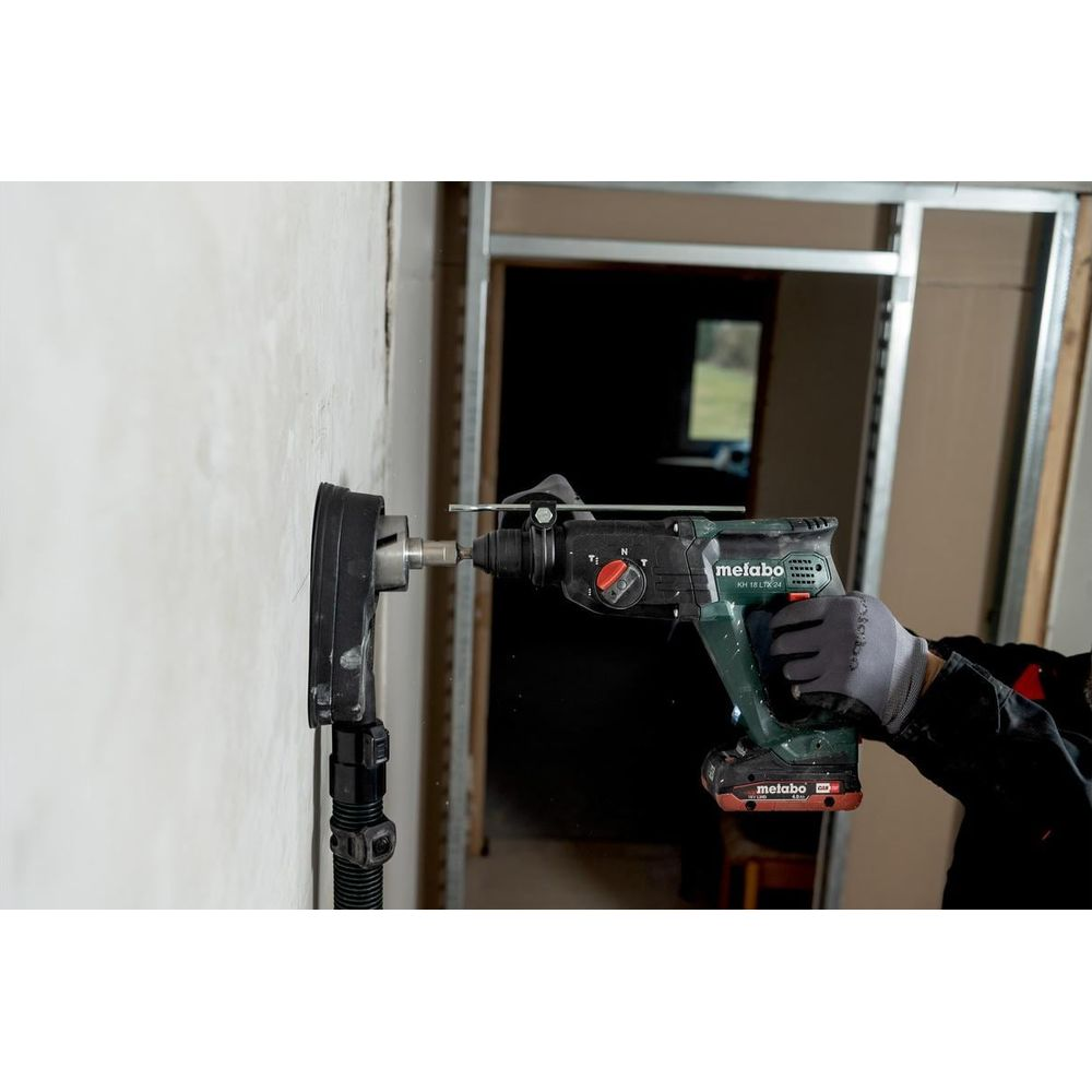Un trabajador perfora un agujero en una pared con un martillo taladro.