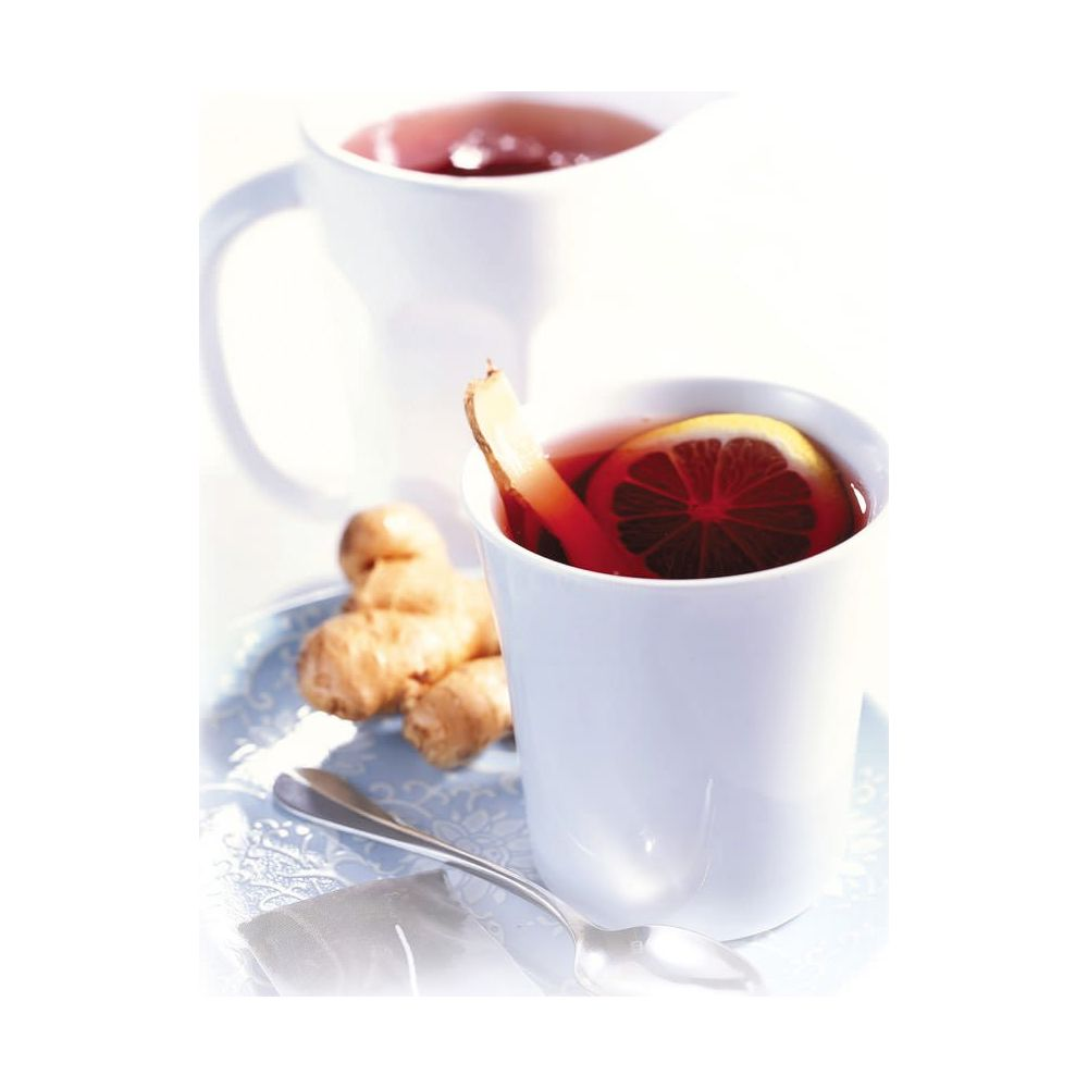 Tazza bianca con bevanda rossa, fetta di limone e zenzero. Brocca sullo sfondo.