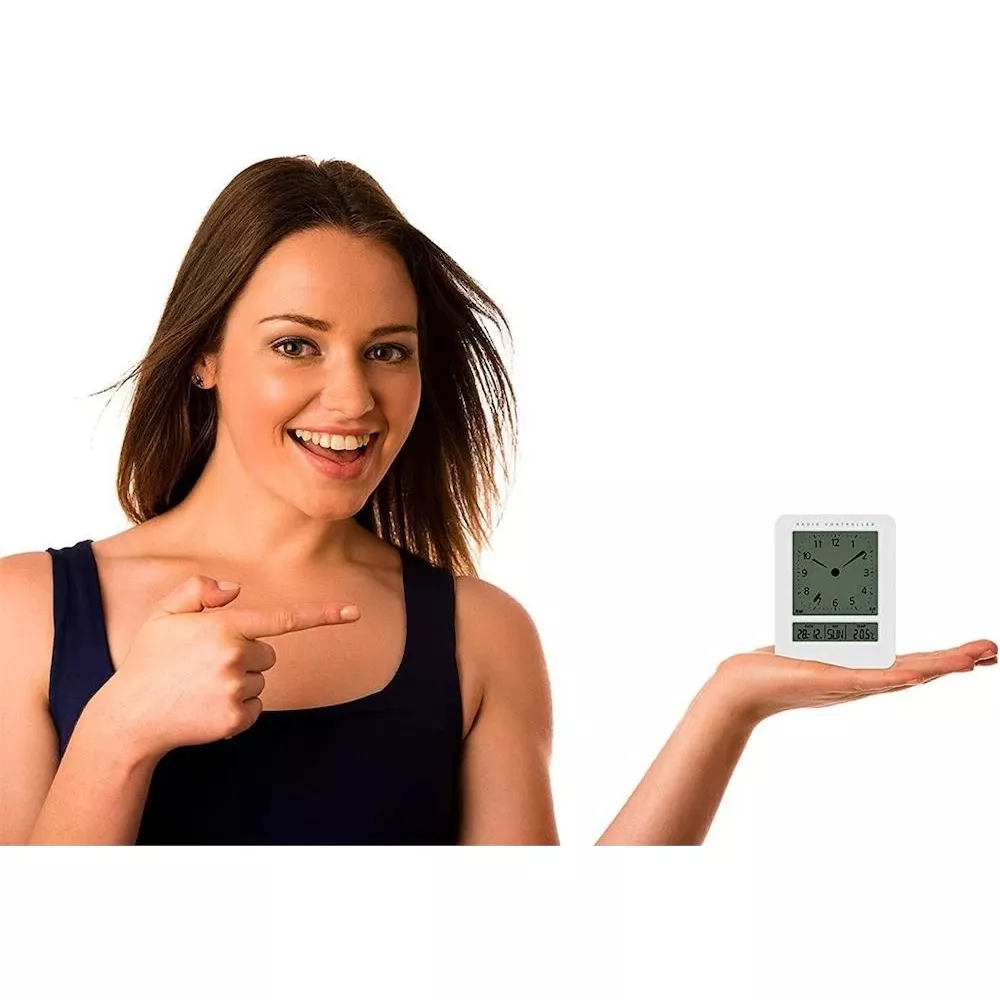 Kobieta w ciemnoniebieskiej bluzce wskazuje na biały zegar cyfrowy na dłoni.