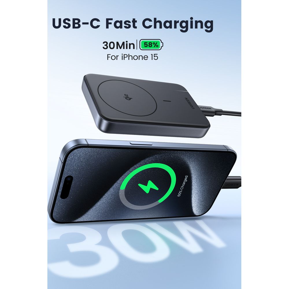 Czarny iPhone 15 ładuje się bezprzewodowo. Obok leży podkładka ładująca.