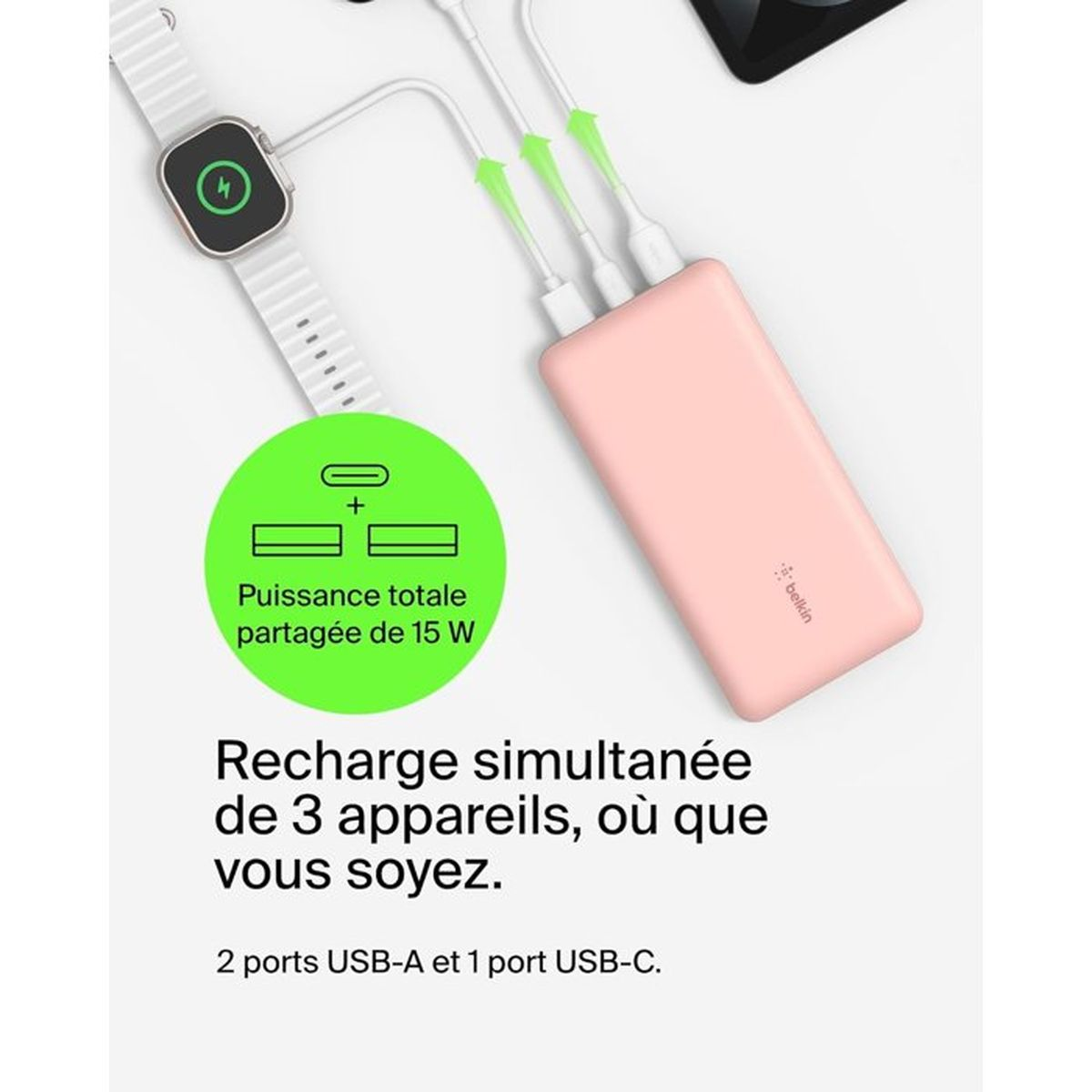 Une banque d'alimentation rose charge une montre connectée et deux autres appareils via USB-A et USB-C.