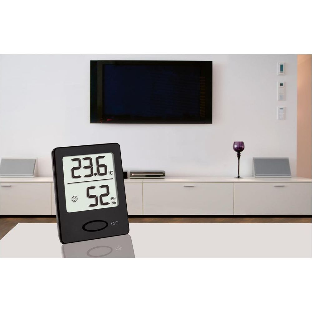 Ein schwarzes Thermometer mit Display zeigt 23,6°C und 52% Luftfeuchtigkeit an.