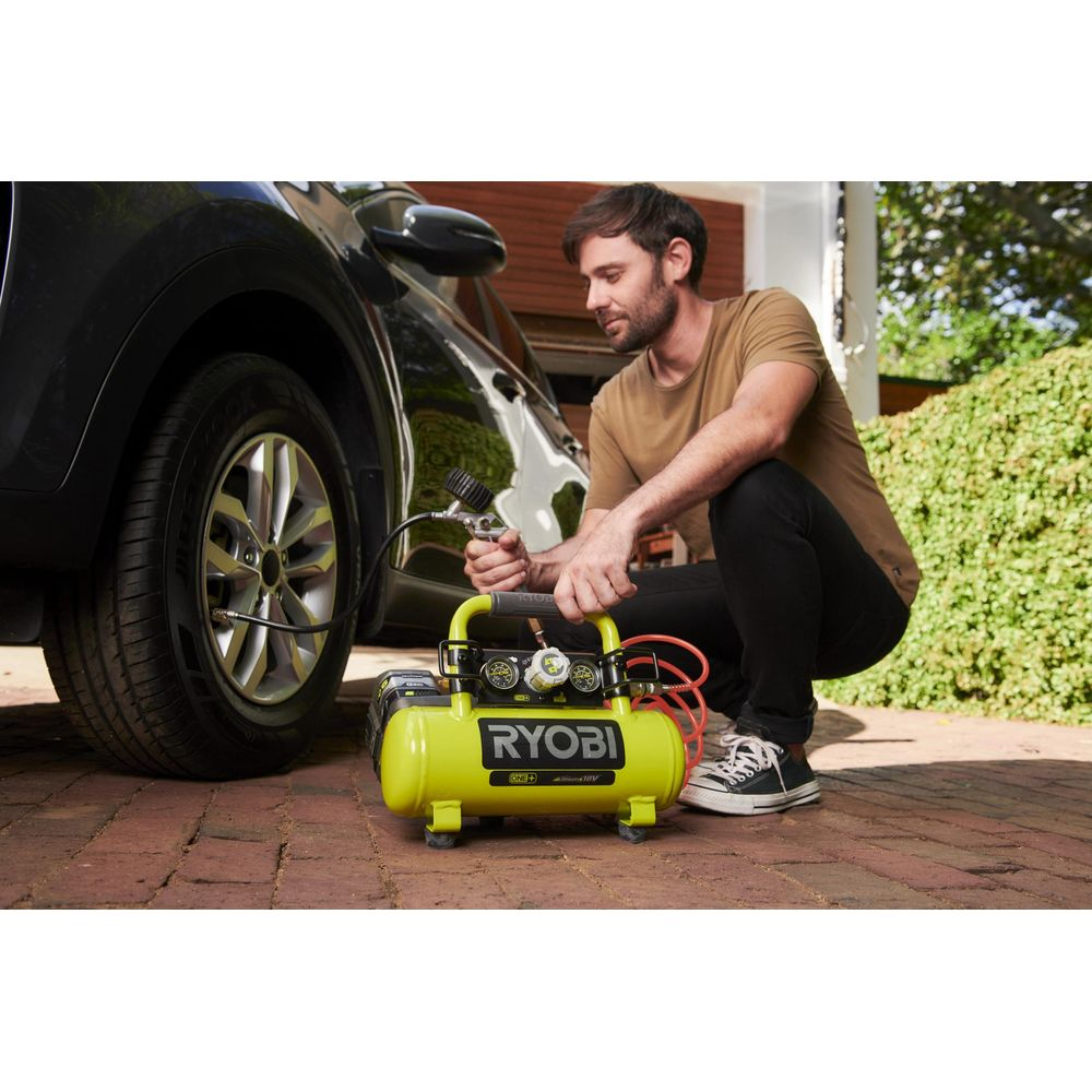 Uomo gonfia pneumatico auto con compressore giallo.