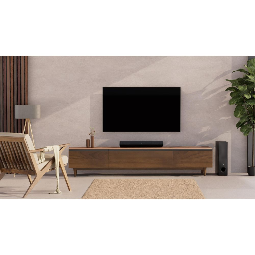Salon moderne avec TV, barre de son, fauteuil et plante.