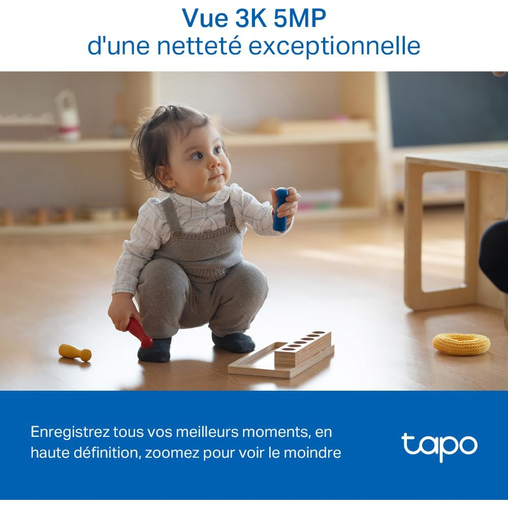 Niemowlę kuca na podłodze, bawiąc się zabawkami. Ujęcie w wysokiej rozdzielczości.