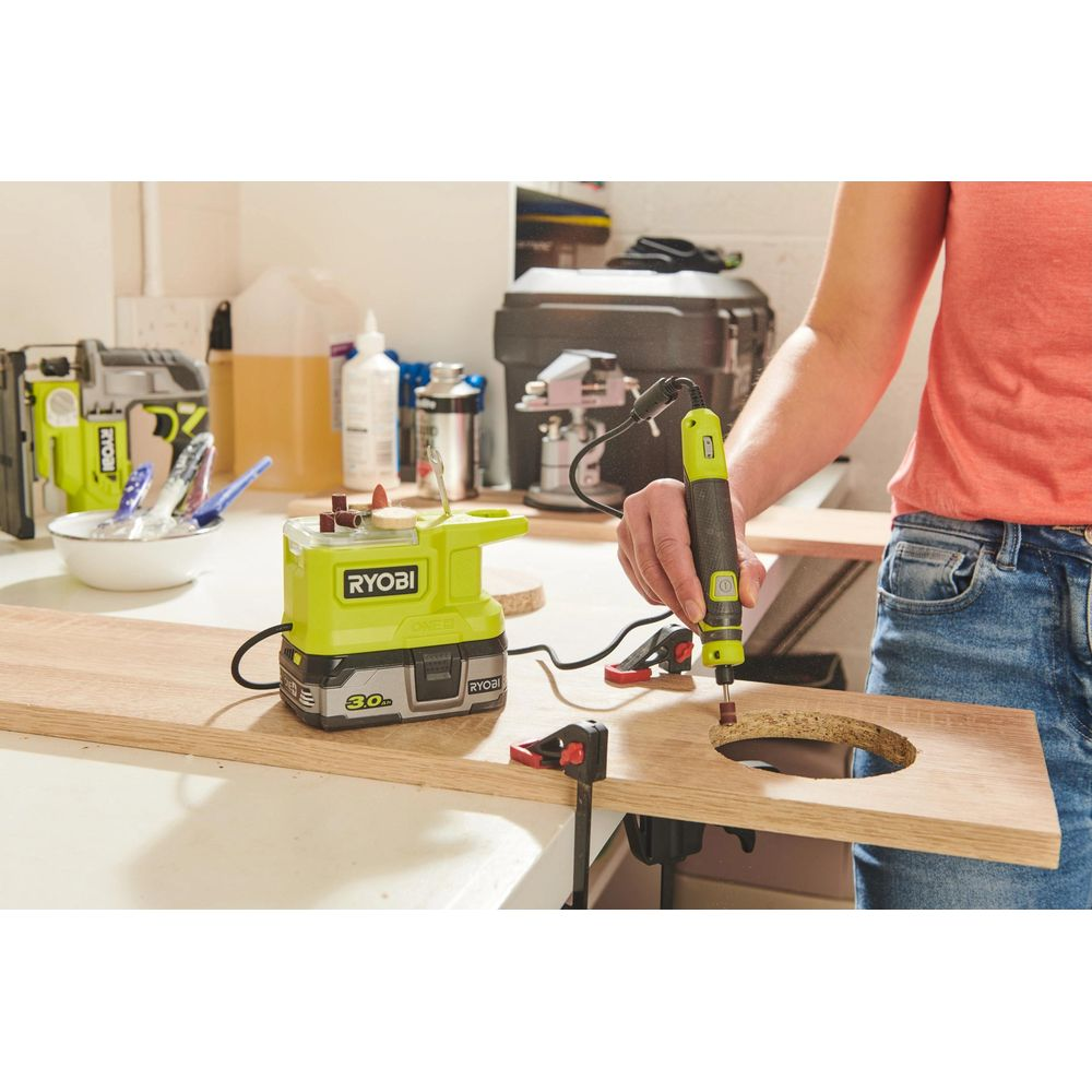 Persona fora tavola legno con attrezzo Ryobi. Banco da lavoro con attrezzi.
