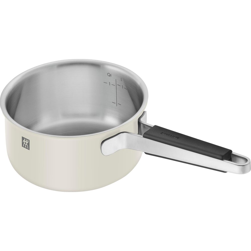 Une casserole couleur crème avec manche argenté et intérieur brillant. Mesures marquées à l'intérieur.