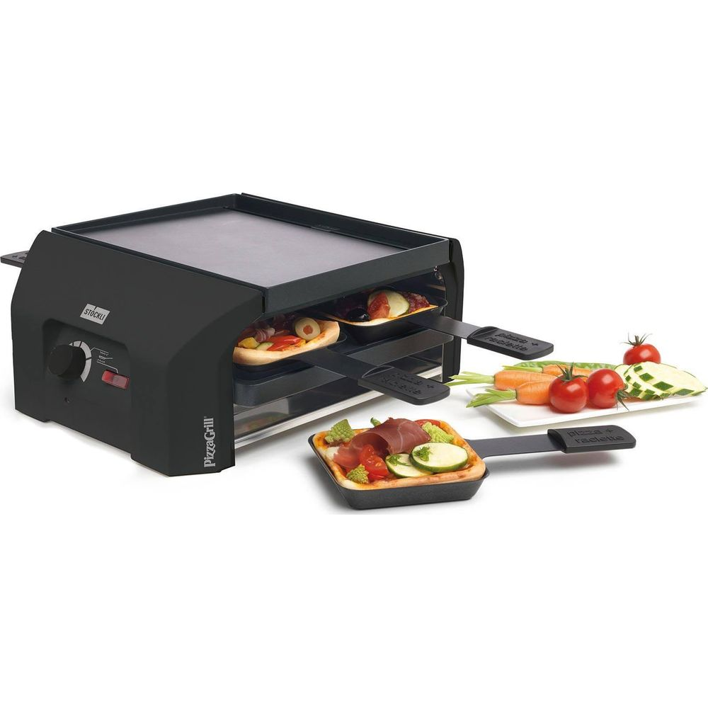 Ein schwarzer Pizza-Grill mit zwei Mini-Pizzen und Gemüse auf Pfannen und einem Teller.